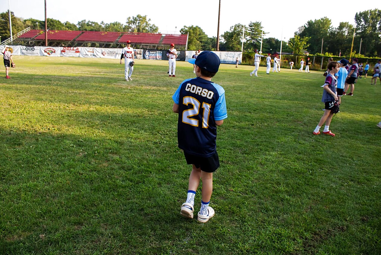 A young fan in the outfield grass during a Field of Dreams night at East Field.